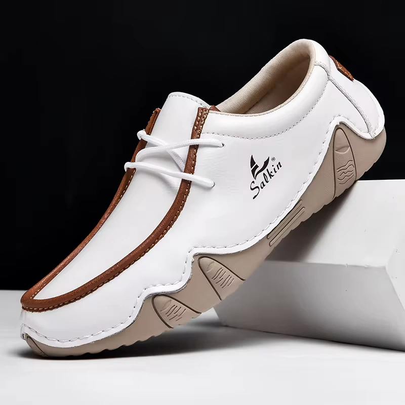 White leather men's loafer shoes, brown trim and lace-up with closure, displayed from the side angle.