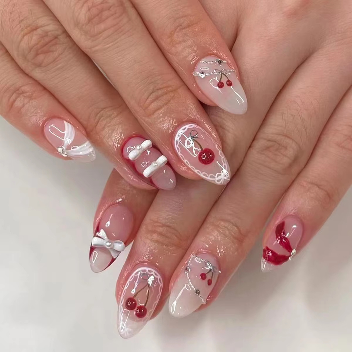 Close-up of hands wearing 24pcs Ins Short Almond False Nails with colorful flower and red strawberry designs, a pink French press-on nail style for sweet girls.